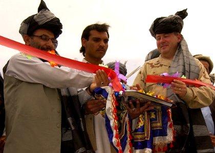 US Navy 070516-A-2013C-015 U.S. Navy Cmdr. Dave Adams and the Governor of Afghanistan's Khowst Province, Arsala Jamal, cut the ribbon signifying the start of construction on a new district center