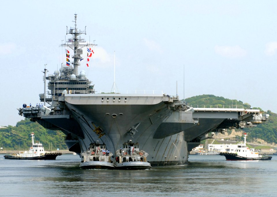US Navy 070515-N-2638R-003 Large harbor tugs assist the USS Kitty Hawk (CV 63) as she departs Commander Fleet Activities Yokosuka to conduct sea trials