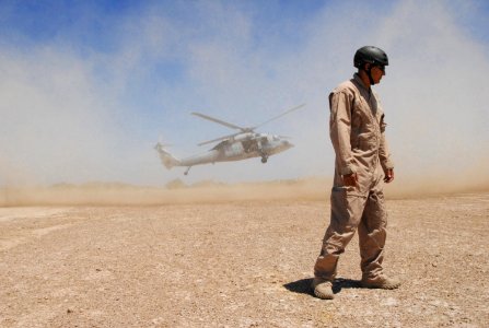 US Navy 070516-N-6597H-339 Explosive Ordnance Disposal 1st Class William Eisenhart, attached to Explosive Ordnance Disposal Mobile Unit 3 turns away from a cloud of dust during fast roping evolutions for a basic tactical traini photo