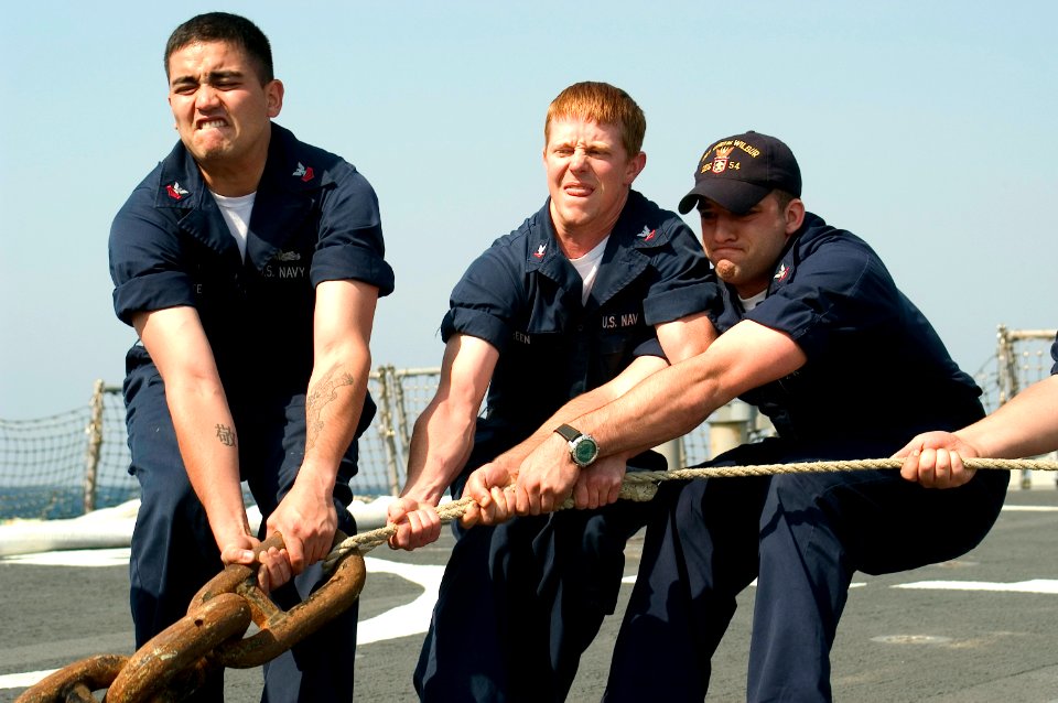 US Navy 070516-N-9520G-005 Cryptologic Technician 1st Class Robert Bonte, Quartermaster 3rd Class Mike Thoumire and Gunner's Mate 3rd Class Timothy Green heave on a anchor chain