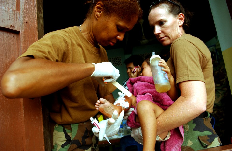 US Navy 070517-F-7806C-002 U.S. Navy Cmdr. Moultrie-Lizana from Detachment F Naval Hospital and Hospital Corpsman 2nd Class Ledbetter from Occupational Hospital Support Unit (OHSU) treats a Thai baby with a burn