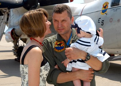 US Navy 070521-N-1082Z-005 Lt. Cmdr. John Fisher greets his wife and seven-month-old daughter at a flight line homecoming on Naval Station Norfolk after returning with the Rawhides of Fleet Logistics Support Squadron (VRC) 40