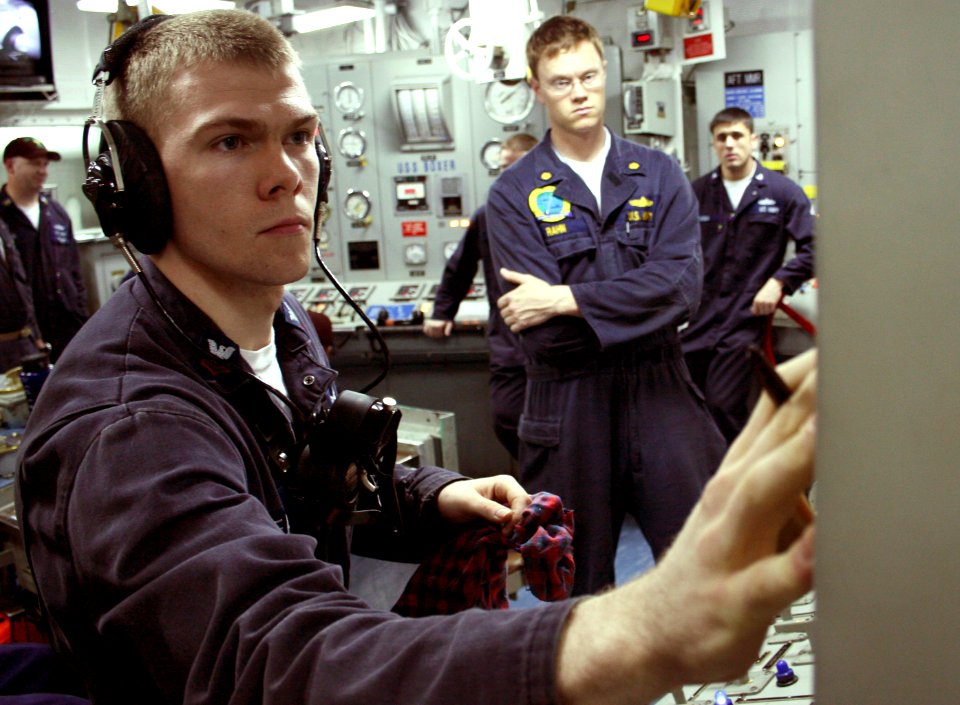 US Navy 070517-N-1328S-003 Electrician's Mate 2nd Class Terry Meacham operates a control panel while an Afloat Training Group Pacific evaluator observes during a Unit Level Training Assessment-Sustainment (ULTRA-S) drill aboard