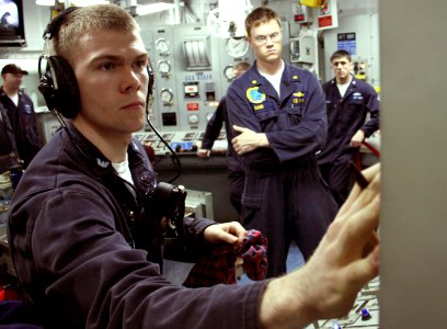 US Navy 070517-N-1328S-003 Electrician's Mate 2nd Class Terry Meacham operates a control panel while an Afloat Training Group Pacific evaluator observes during a Unit Level Training Assessment-Sustainment (ULTRA-S) drill aboard