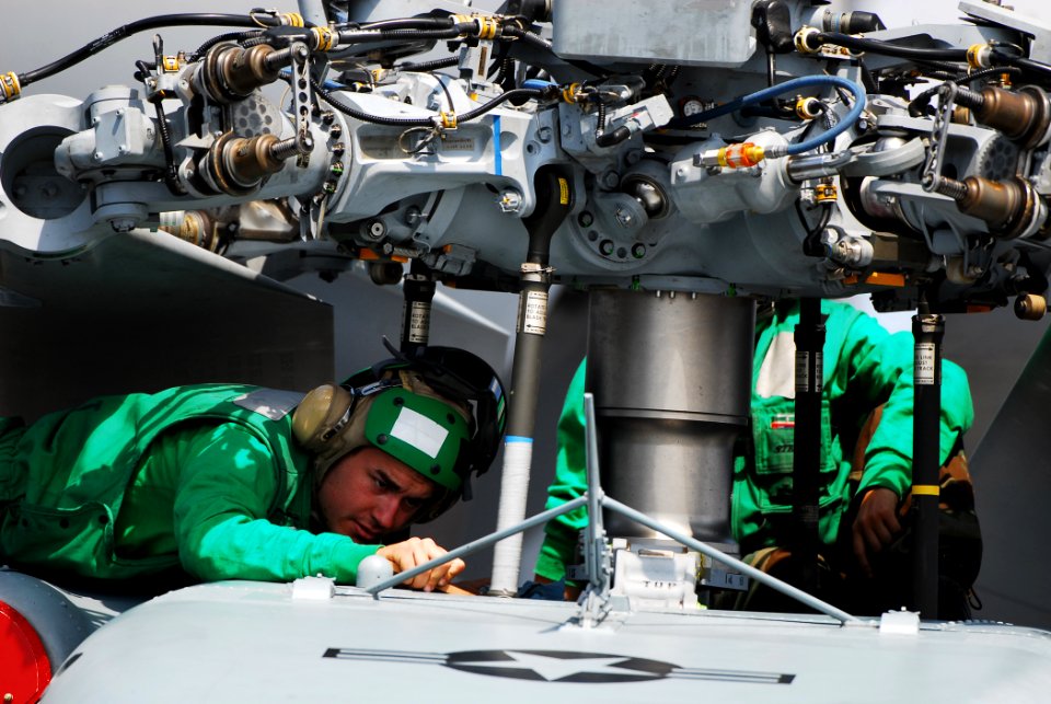 US Navy 070519-N-0841E-043 Aviation Machinist's Mate Airman Christopher Bohnert, assigned to Helicopter Sea Combat Squadron (HSC) 22, performs maintenance on an MH-60S Sea Knight during a break in flight operations aboard amphi
