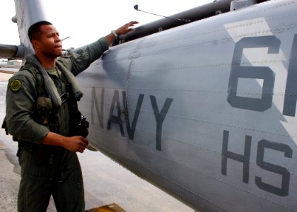 US Navy 070518-N-8544C-007 Aviation Warfare Systems Operator 1st Class Brandon Lee performs preflight checks on a helicopter