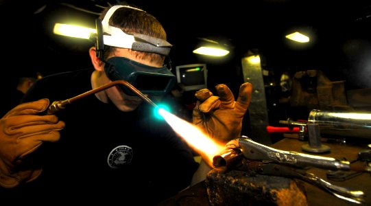 US Navy 070517-N-9928E-009 Hull Technician Fireman Zach Carver brazes a pipe fitting with an oxy-acetylene torch in engineering department's welding shop aboard Nimitz-class aircraft carrier USS John C. Stennis (CVN 74)
