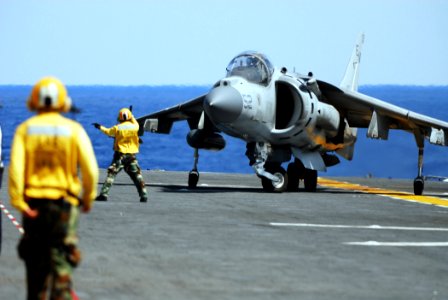 US Navy 070519-N-0841E-095 Aviation Boatwain's Mate (Handling) 2nd Class Charles Imanil directs an AV-8B Harrier II, from Marine Medium Helicopter Squadron (HMM) 261 (reinforced), onto the flight deck aboard amphibious assault