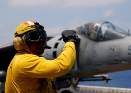 US Navy 070522-N-0841E-370 Aviation Boatswain's Mate Handler 2nd Class Artis Morris assigned to air department directs an AV-8B Harrier II from Marine Medium Helicopter Squadron (HMM) 261