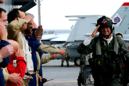 US Navy 070518-N-8591H-103 Capt. Ed McNamee renders final salutes while passing fellow officers after his change of command ceremony on the flight deck of USS Kitty Hawk (CV 63)