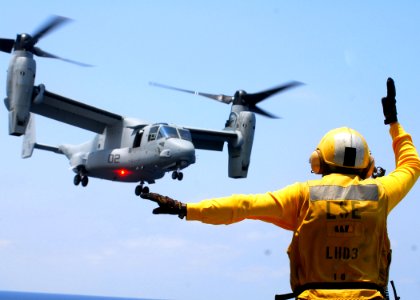 US Navy 070522-N-0841E-410 Aviation Boatswain's Mate Handling 2nd Class Juan Pena assigned to air department guides an MV-22 Osprey from Marine Medium Tiltrotor Squadron (VMM) 162