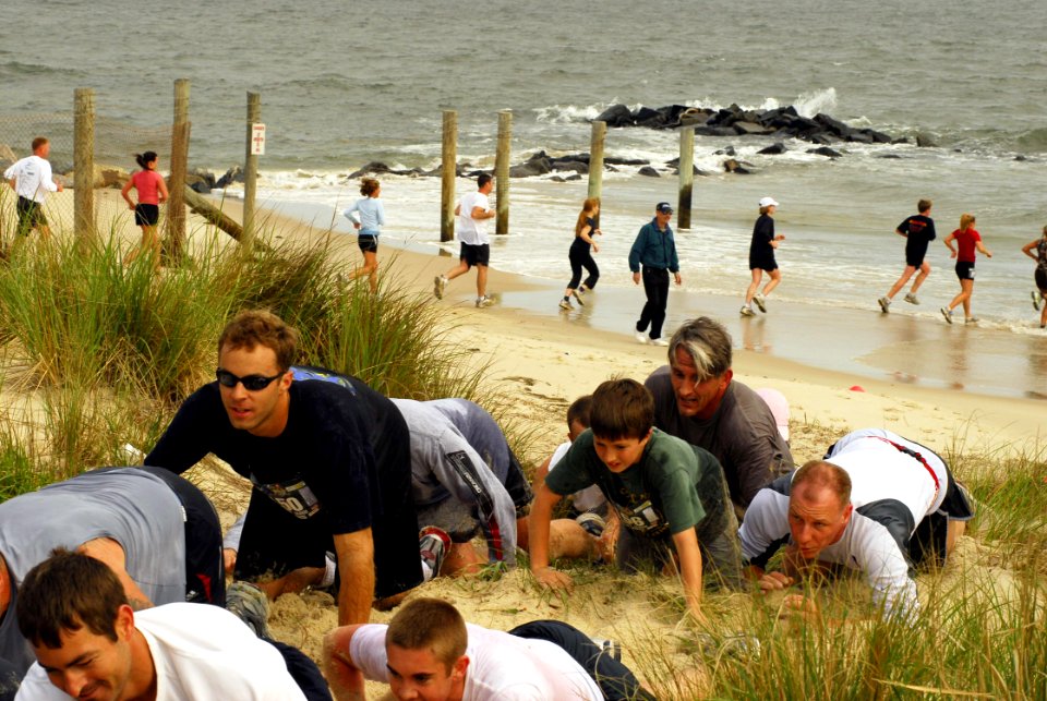 US Navy 070519-N-1688B-211 After running through the surf, participants of the 3rd annual Rudy Run SEAL Challenge crawl through the sand as a part of the eight-kilometer race