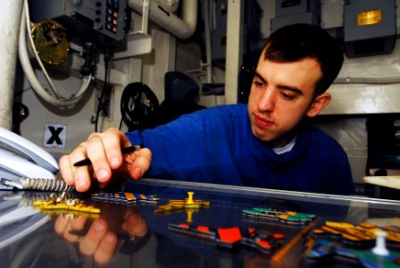 US Navy 070520-N-9928E-003 Aviation Boatswain's Mate Airman Jason Skonieczny plots aircraft movements on the Ouija board in hangar deck control,