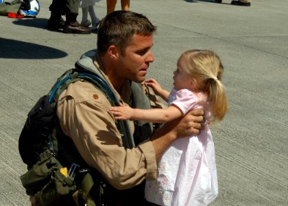 US Navy 070522-N-6247M-009 Lt. Cmdr. Adam Carlstrom greets his daughter during a homecoming ceremony at Naval Air Station Whidbey Island photo