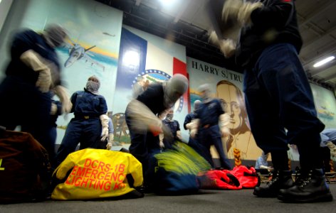 US Navy 070520-N-5345W-022 Sailors assigned to repair locker one bravo rush to organize their emergency response equipment in hangar bay two during a general quarters (GQ) drill aboard Nimitz-class aircraft carrier USS Harry S