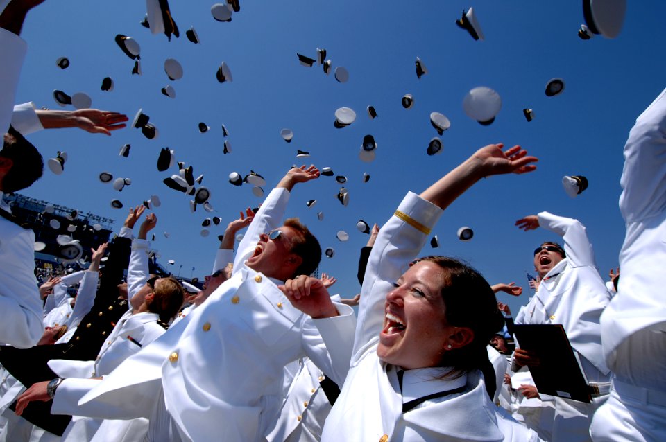 US Navy 070525-N-3642E-725 Ens. Morgan Kitchen, lower-right, a newly commissioned U.S. Naval Officer celebrates her new rank with the traditional tossing of the Midshipmen cover