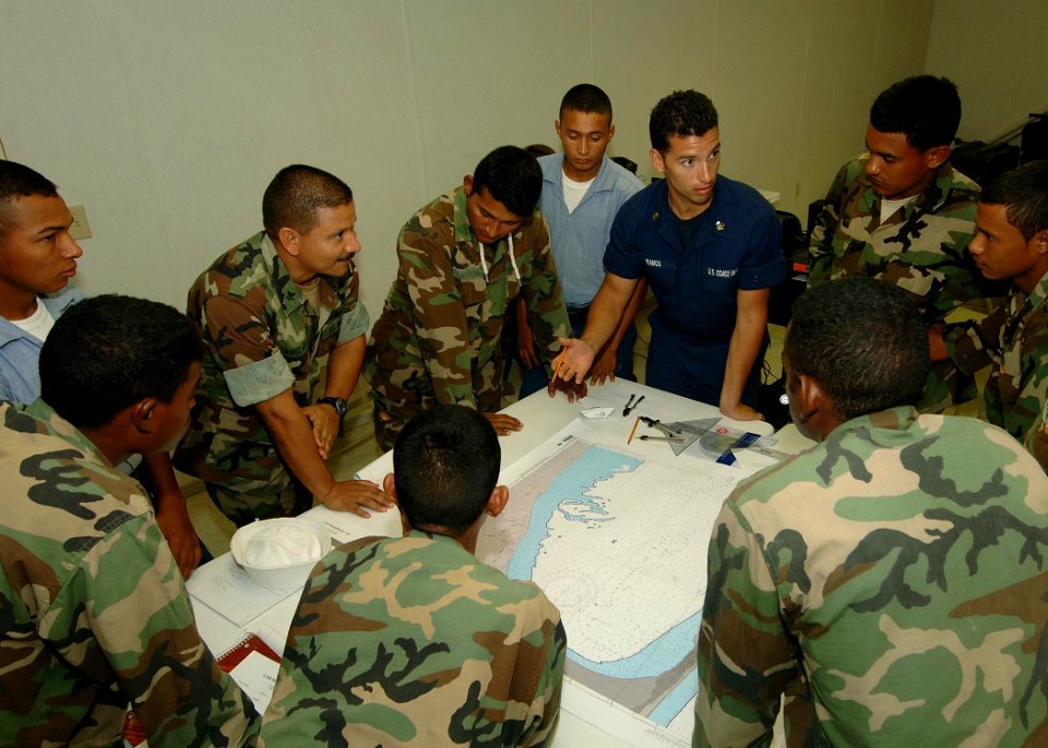 US Navy 070523-N-0989H-055 Boatswain's Mate 1st Class Ernest Ramos, of the U.S. Coast Guard International Training Division, assists Honduran sailors and Marine force personnel to find the latitude and longitude for a given po