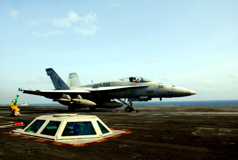 US Navy 070520-N-5484G-013 Aviation Boatswain's Mate Chief Andre Walton gives a thumbs up as an F-A-18 Hornet roars past aboard the nuclear-powered aircraft carrier USS Nimitz (CVN 68)