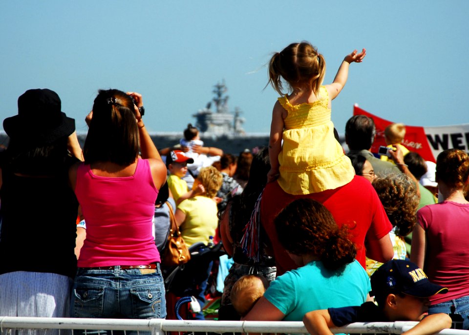 US Navy 070523-N-7241L-046 Family and friends wait as Sailors assigned to Nimitz-class aircraft carrier USS Dwight D. Eisenhower (CVN 69) return to Naval Station Norfolk after the longest deployment by a carrier strike group si