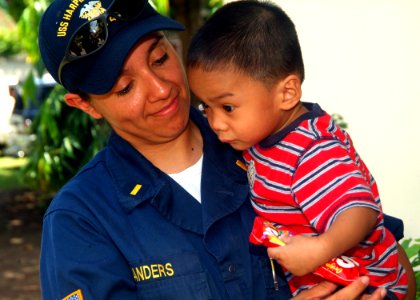 US Navy 070531-N-0120A-110 Ensign Jennifer A. Sanders assigned to dock landing ship USS Harpers Ferry (LSD 49), holds a Filipino child