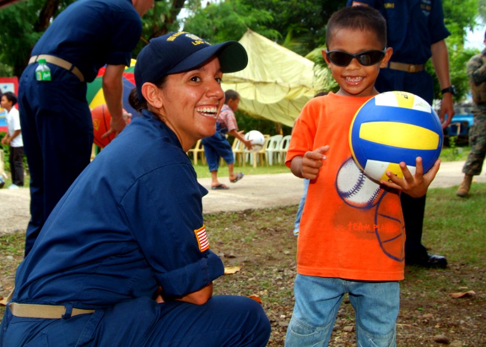 US Navy 070531-N-0120A-188 Ensign Jennifer A. Sanders, assigned to dock landing ship USS Harpers Ferry (LSD 49), plays with a Filipino child during a friendship-building project between Harpers Ferry Sailors and a Zamboanga chi