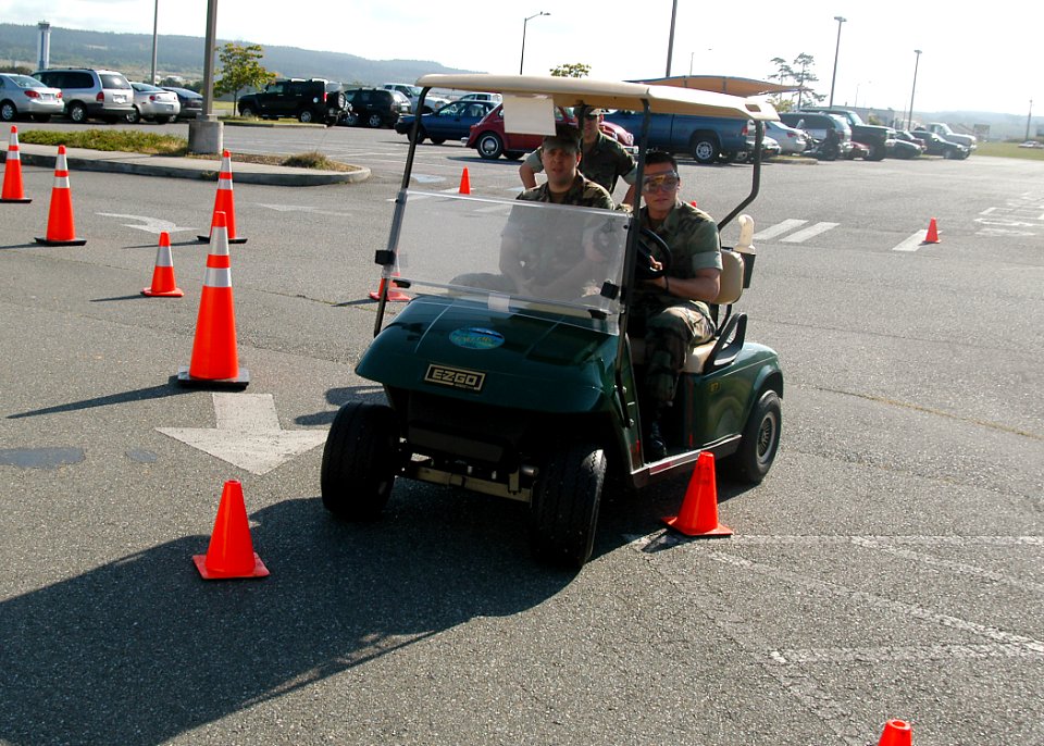 US Navy 070522-N-6247M-007 Master at Arms 3rd Class David Barnett, from Belgrade, Mt. (Driver), and Master at Arms 1st Class Daniel Bellwood, from Methuen, Mass. (Passenger), drive a golf cart through traffic cones while wearin