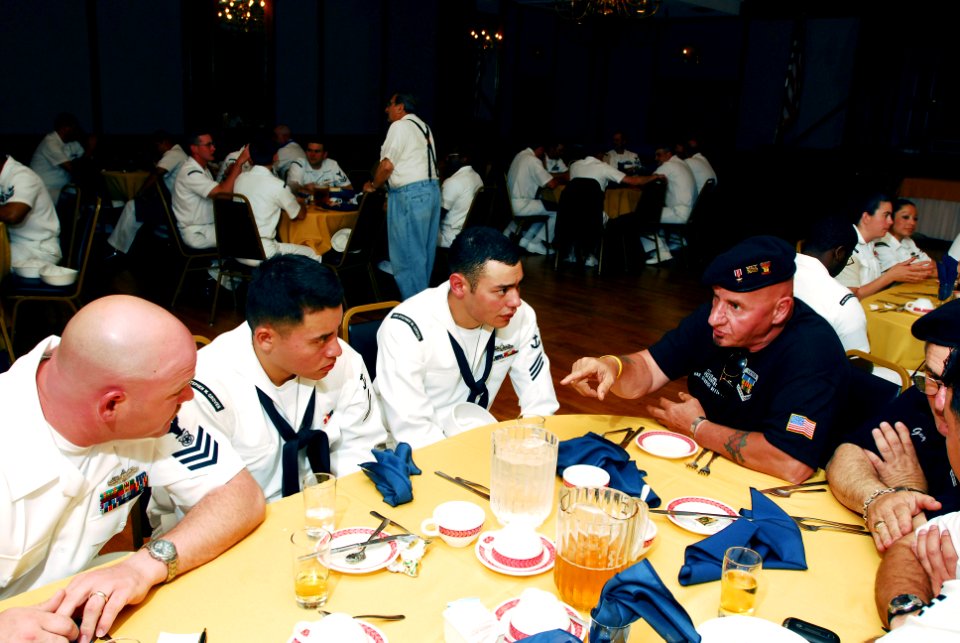 US Navy 070524-N-5758H-028 Santi Ranno, a retired Marine Corps veteran, shares past experiences in the military to Sailors assigned to guided-missile frigate USS Stephen W. Groves (FFG 29) during a community luncheon with veter