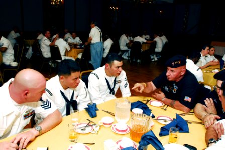 US Navy 070524-N-5758H-028 Santi Ranno, a retired Marine Corps veteran, shares past experiences in the military to Sailors assigned to guided-missile frigate USS Stephen W. Groves (FFG 29) during a community luncheon with veter