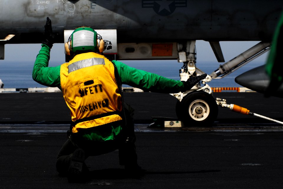 US Navy 070524-N-9928E-071 Aviation Boatswain's Mate (Equipment) Airman Brian Rothblatt signals an F-A-18C Hornet, from the