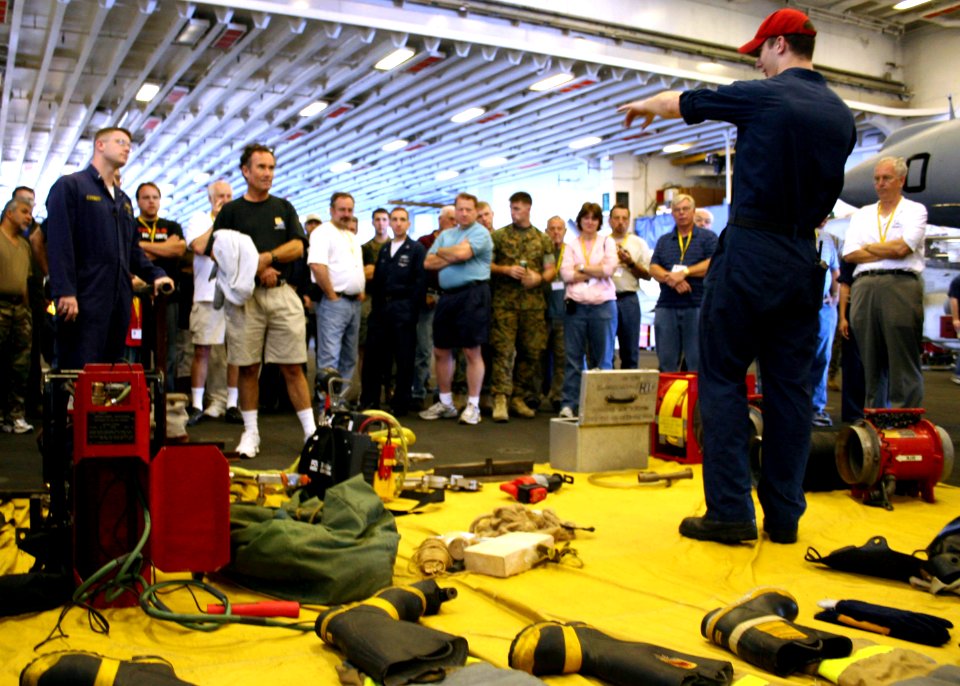 US Navy 070527-N-1328S-003 Damage Controlman 2nd Class Steven Petroskey teaches family and friends about fire-fighting capabilities aboard USS Boxer (LHD 4) as part of the ship's Tiger Cruise