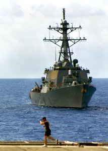 US Navy 070529-N-5067K-028 A Marine runs the flight deck of amphibious transport dock USS Juneau as Arleigh Burke-class destroyer USS Paul Hamilton (DDG 60) steams alongside