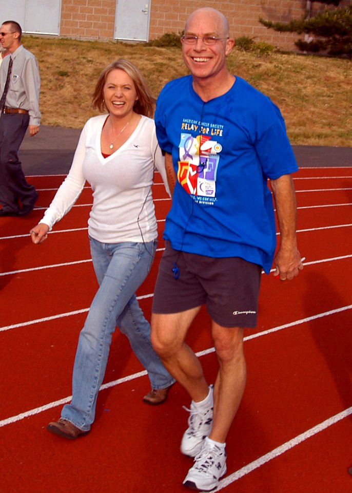 US Navy 070602-N-6247M-007 Capt. Martin Clark and Dental Technician Shantel Porter walk laps around the track during the Relay for Life