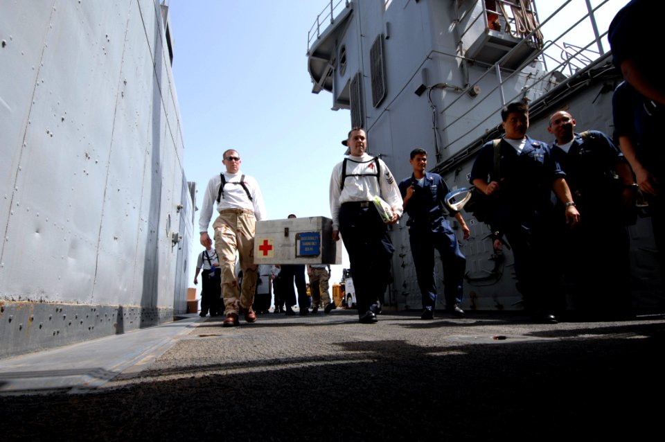 US Navy 070605-N-3729H-010 Lt. Cmdr. Anthony Baldwin-Voeks (left) and Hospital Corpsman 1st Class Juan Guedea both assigned to the Nimitz-Class aircraft carrier USS John C. Stennis (CVN 74) transport medical supplies