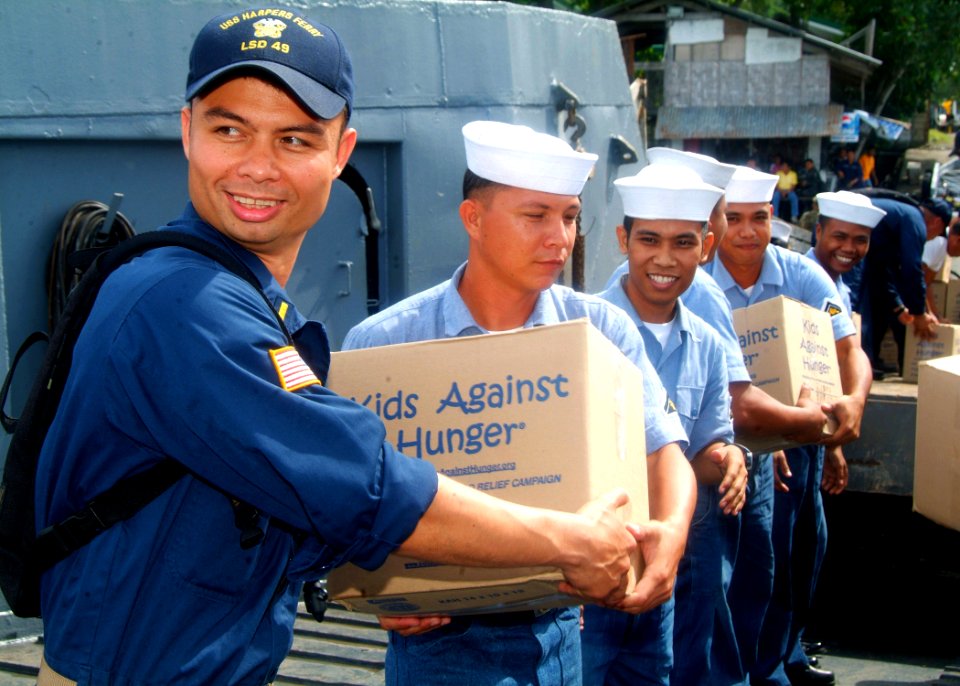 US Navy 070531-N-0120A-007 Ensign John J. Burke, assigned to dock landing ship USS Harpers Ferry (LSD 49), helps Philippine navy sailors load food and supplies onto a truck for delivery to an orphanage