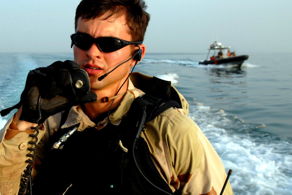 US Navy 070603-N-0684R-313 Lt. j.g. Tom Hennessey, officer in charge of guided-missile destroyer USS Preble's (DDG 88) visit, board, search and seizure (VBSS) team, contacts Preble to receive permission to return to the ship