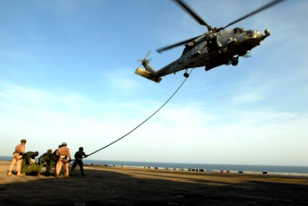 US Navy 070606-N-2659P-459 Explosive Ordnance Disposal personnel along with Navy Divers pick up the slack on a line used to repel from an HH-60H Seahawk photo
