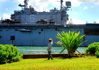 US Navy 070601-N-5476H-062 Davis Wolf, age 5, waves good-bye to Sailors aboard USS Peleliu (LHA 5), as the amphibious assault ship leaves Naval Station Pearl Harbor