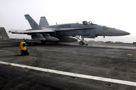 US Navy 070603-N-0890S-019 A Sailor signals to the pilot of an F-A-18A Hornet assigned to the Red Devils of Marine Fighter Attack Squadron (VMFA) 232, prior to launch