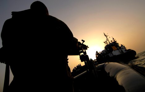 US Navy 070604-N-0684R-126 Boatswain's Mate 2nd Class Jared Klevens mans a .60-caliber machine gun as the visit, board, search and seizure (VBSS) team assigned to guided-missile destroyer USS Preble (DDG 88) approaches a tugboa