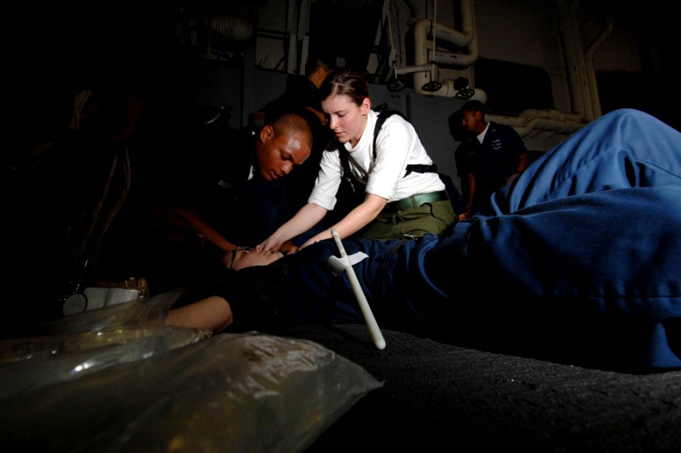US Navy 070605-N-3729H-027 Hospital Corpsman 3rd Class Lauren Ash attached to the Argonauts of Strike Fighter Squadron (VFA) 147 (right) performs medical casualty procedures to a simulated injured citizen aboard amphibious tran