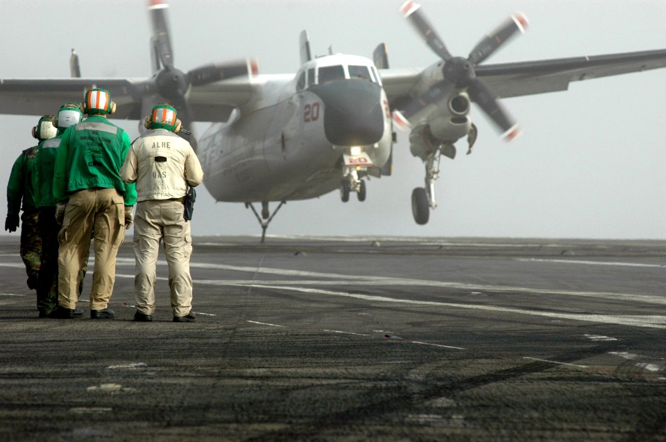 US Navy 070603-N-0890S-032 Sailors standby as an C-2 Greyhound assigned to the Providers of Carrier Logistics Support Squadron (VRC) 30 lands on the flight deck of the nuclear-powered aircraft carrier USS Nimitz (CVN 68)