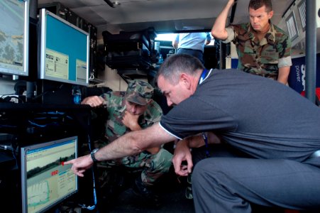 US Navy 070606-N-2456S-225 Jerry Fitzmorris, Raytheon Program Manager shows computer systems to Senior Chief Electronics Technician Scott Kelley, and Lt. William Swinford, during the Multi-Agency Craft Conference (MACC) June 6