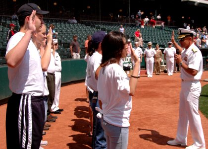 US Navy 070604-N-8497H-038 Director of Global Operations (J3), United States Strategic Command, Rear Adm. Doug McClain swears in new Sailors in the delayed entry program before a Redhawks game