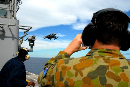 US Navy 070611-N-4124C-052 Royal Australian Army Capt. Peter Brown, operations officer for the 72nd EW Squadron, 7th Signal Regiment, takes a snap shot of an AV-8B Harrier II aboard USS Essex (LHD 2)