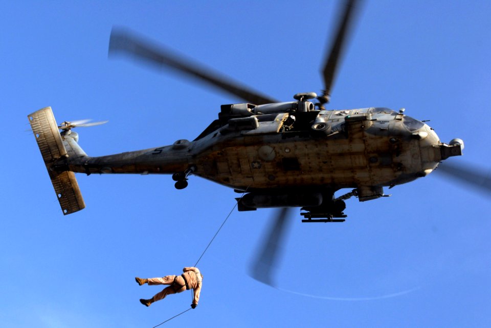 US Navy 070606-N-2659P-284 Navy Diver 1st Class Geno Jahrling rappels from an HH-60H Seahawk, attached to the Eightballers of Helicopter Anti-Submarine Squadron (HS) 8, over amphibious assault ship USS Bonhomme Richard (LHD 6)