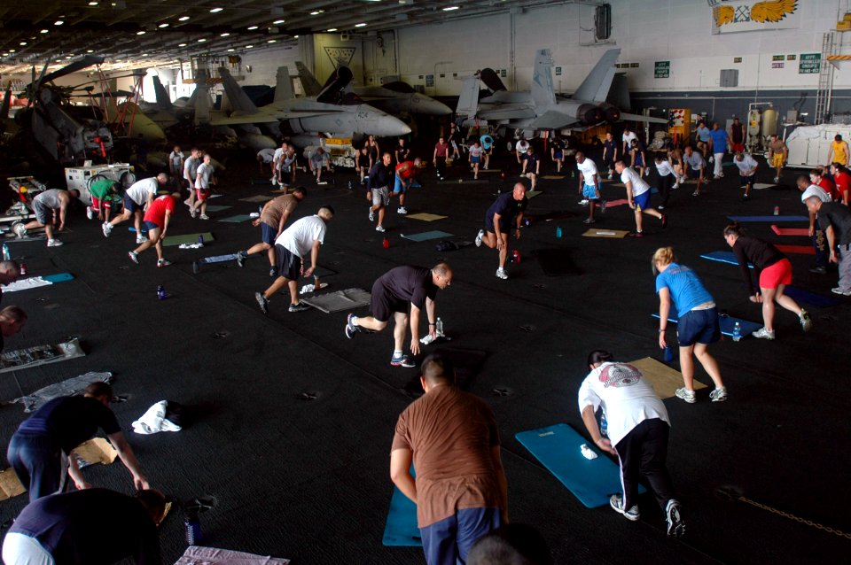 US Navy 070608-N-0890S-056 Sailors participate in a group physical training session in the hangar bay aboard nuclear-powered aircraft carrier USS Nimitz (CVN 68)