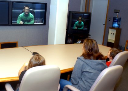 US Navy 070612-N-6247M-001 Aviation Survival Equipmentman 1st Class Dustin Schmidt talks to his family during a Video Teleconferencing family morale call photo