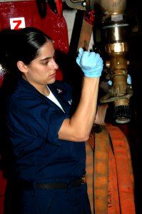 US Navy 070612-N-7128A-018 Hospital Corpsman 3rd Class Crystal Prolo attaches a fire hose nozzle to a fire station while performing preventative maintenance aboard nuclear-powered aircraft carrier USS Nimitz (CVN 68)