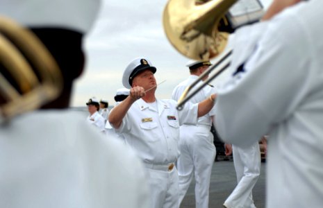 US Navy 070615-N-7088A-002 Senior Chief Musician David Wiley, conductor for the Navy Showband leads the band members in Anchors Away, aboard Military Sealift Command hospital ship USNS Comfort (T-AH 20), as the ship departs fro