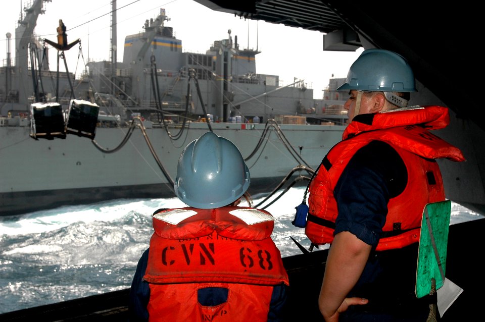 US Navy 070616-N-9760Z-007 Seaman Erik Pardo signals to slow the cargo down while conducting a replenishment at sea with Military Sealift Command fast combat support ship USNS Rainier (T-AOE 7) aboard nuclear-powered aircraft c